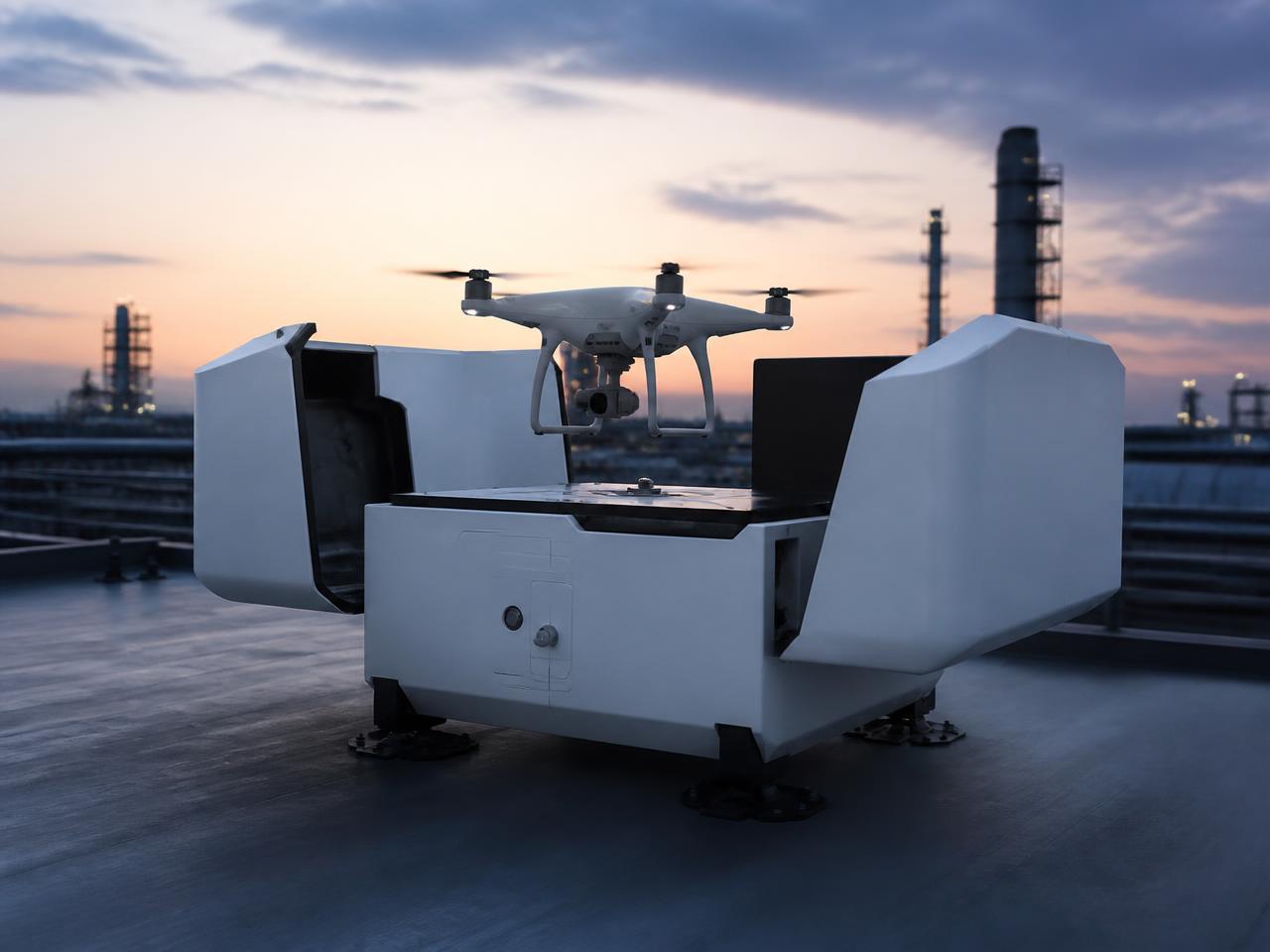 Automated drone-in-a-box docking station on an industrial rooftop with a drone landing